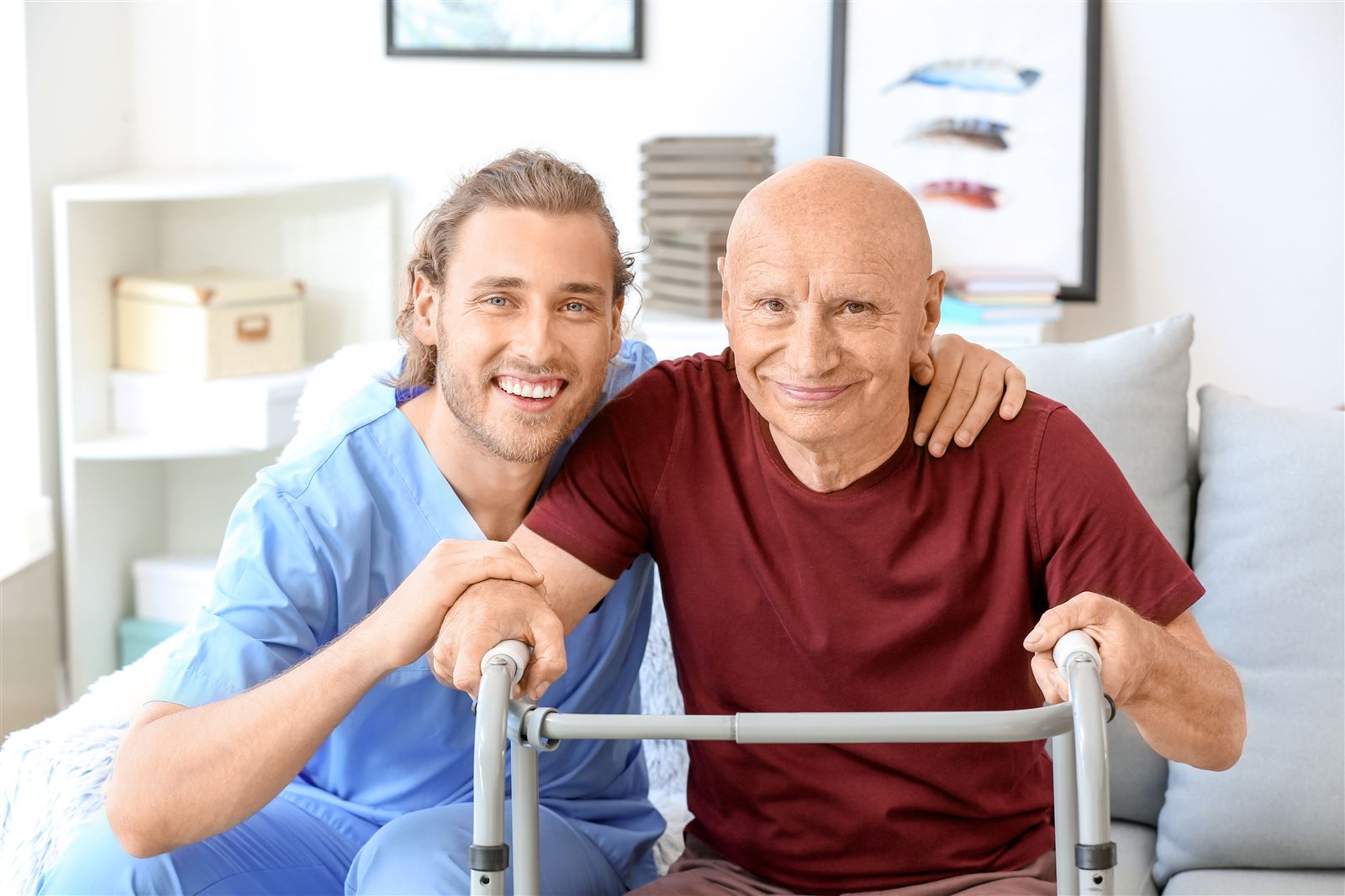 A caregiver supporting a senior man using his walker at home